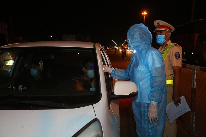 Nhân viên y tế đo nhiệt độ cho tài xế, hành khách đến TP.HCM tại chốt kiểm soát dịch dưới chân cầu Đồng Nai - Ảnh: Hữu Khoa Nhân viên y tế đo nhiệt độ cho tài xế, hành khách đến TP.HCM tại chốt kiểm soát dịch dưới chân cầu Đồng Nai - Ảnh: Hữu Khoa