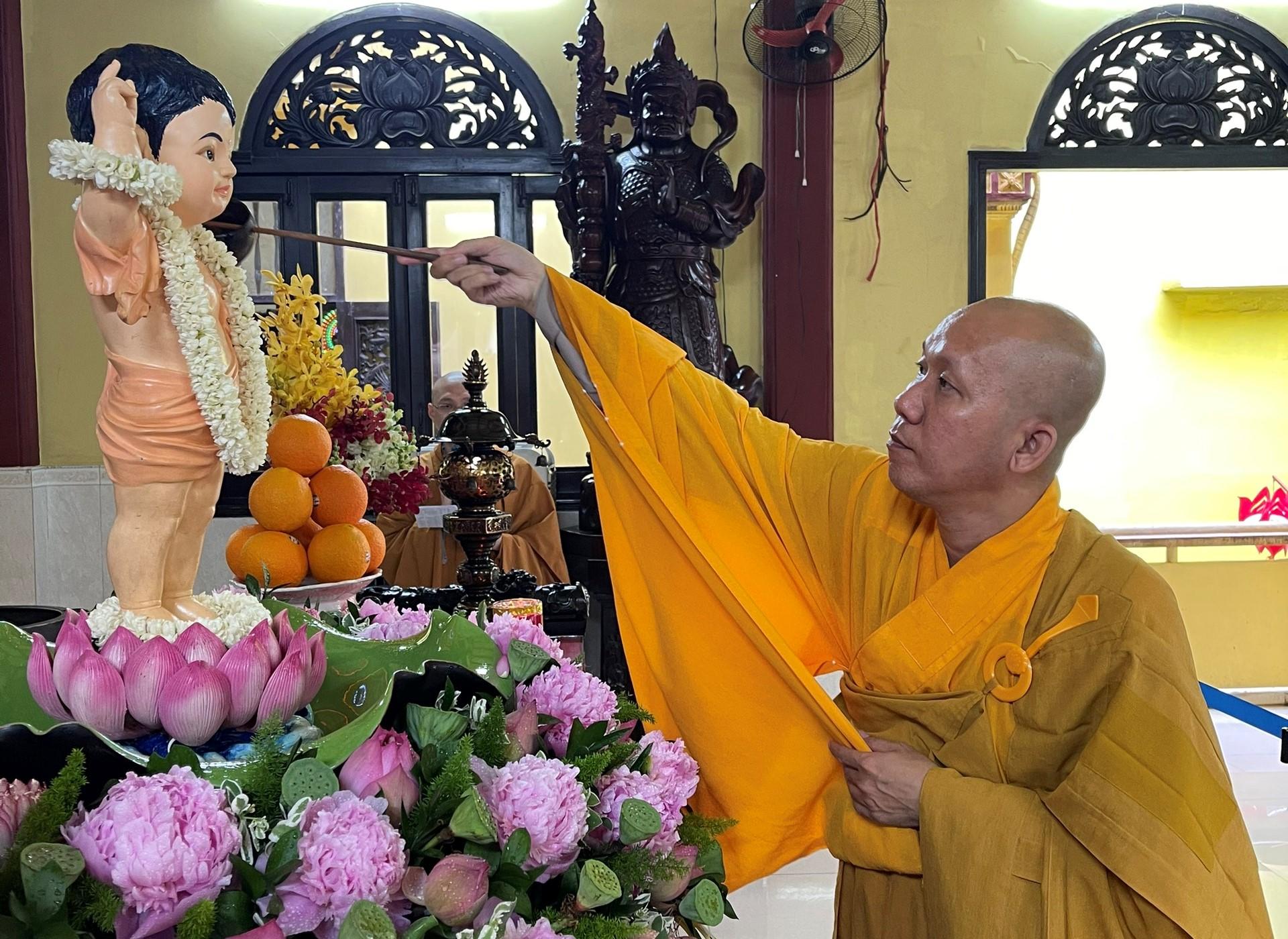 Tưới nước lên kim thân sơ sinh Đức Bổn Sư