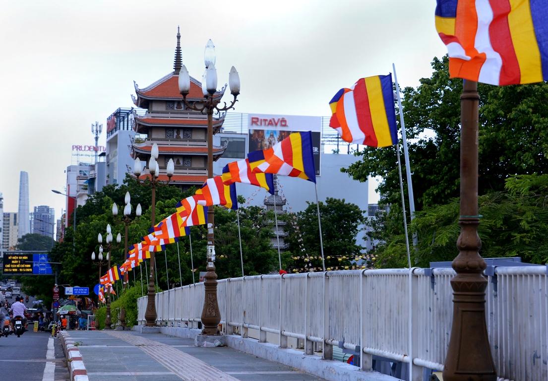 Sắc màu cờ Phật giáo mừng Phật đản trên đường phố giữa mùa dịch - Ảnh: Bảo Toàn/BGN