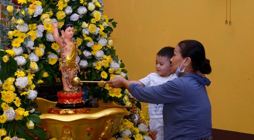 Bà hướng dẫn cháu Tắm Phật - Ảnh: Bảo Toàn/BGN
