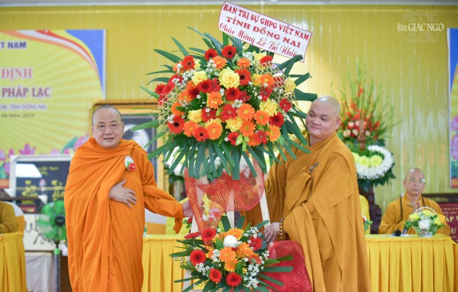 Hòa thượng Thích Bửu Chánh, Phó ban Thường trực Ban Trị sự GHPGVN tỉnh Đồng Nai trao lẵng hoa chúc mừng của Ban Trị sự đến Đại đức tân trụ trì