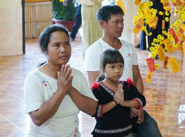 Các em nhỏ đồng bào dân tộc được cha mẹ hướng dẫn đến chùa lễ Phật