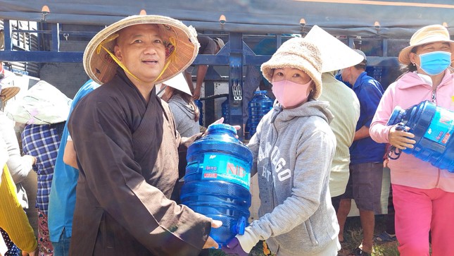 Thượng tọa Thích Giác Nguyên tận tay trao những bình nước uống đến bà con