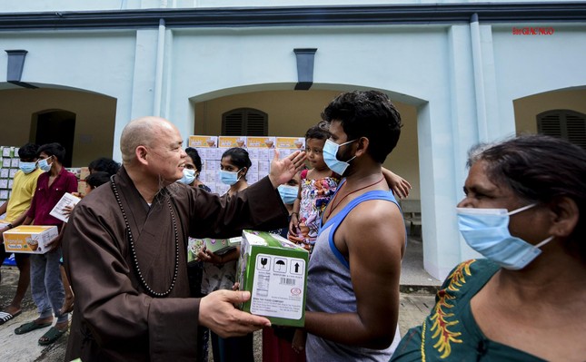 Một em bé vui vẻ đón nhận món quà từ chư tôn đức Tăng Một em bé vui vẻ đón nhận món quà từ chư tôn đức Tăng