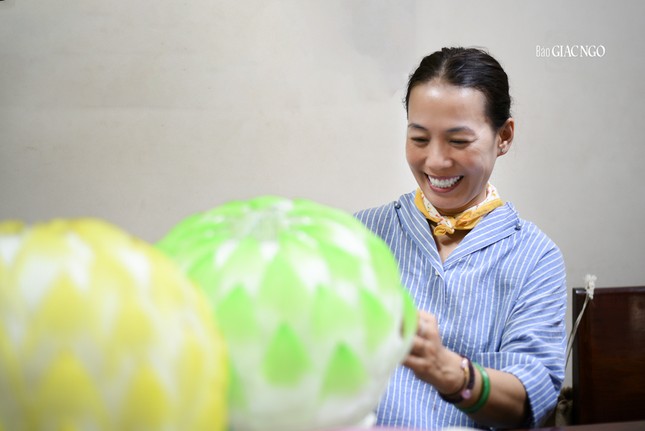 Nụ cười của một nữ Phật tử đang làm lồng đèn tại chùa Định Thành