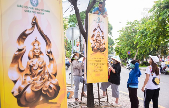 Các bạn trẻ treo áp phích tưởng niệm 60 năm Bồ-tát Thích Quảng Đức vị pháp thiêu thân bên dòng kênh Nhiêu Lộc