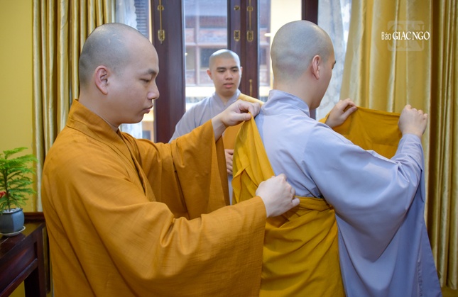 Một thầy Tỳ-kheo đang hướng dẫn các vị giới tử Sa-di cách đắp y phục