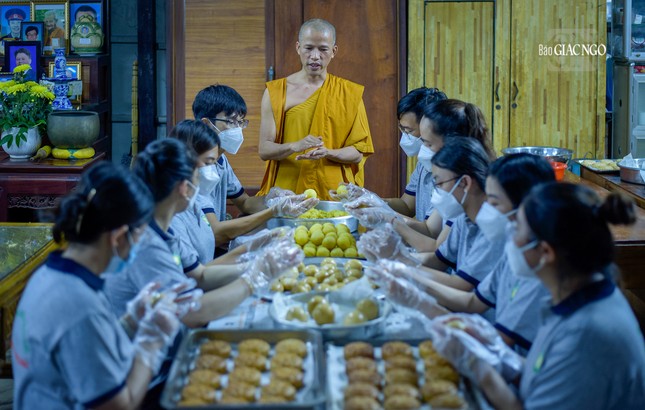 Đại đức Thích Minh Phú, Quản sự tịnh xá Ngọc Chánh đang hướng dẫn các bạn trẻ đưa &quot;chất liệu yêu thương&quot; của mình vào trong mỗi chiếc bánh trung thu. Điều này không chỉ mang đến hạnh phúc cho các em nhỏ mà còn mang lại giá trị lớn lao cho chính bản thân của mình