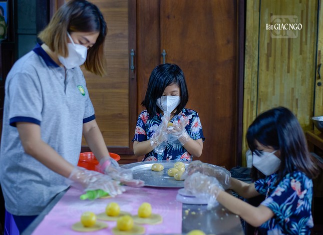 Hình ảnh gia đình bé Cát Uyên và Cát Vi tham gia làm bánh tại tịnh xá Ngọc Chánh. Mặc dù còn nhỏ nhưng các em đã biết học cách làm phước, chia sẻ yêu thương đến với mọi người