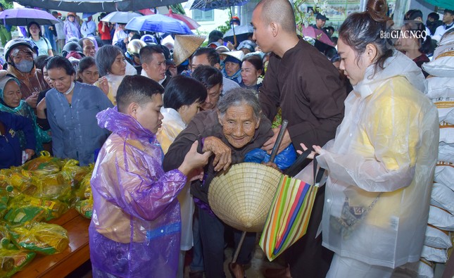 Hình ảnh một cụ già lớn tuổi được các tình nguyện viên chùa Long Hương hỗ trợ nhận quà