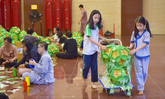 Bé Thiên Ngân (11 tuổi) và bé Thanh Thảo (9 tuổi) phụ giúp làm lồng đèn cùng với mọi người tại Việt Nam Quốc Tự