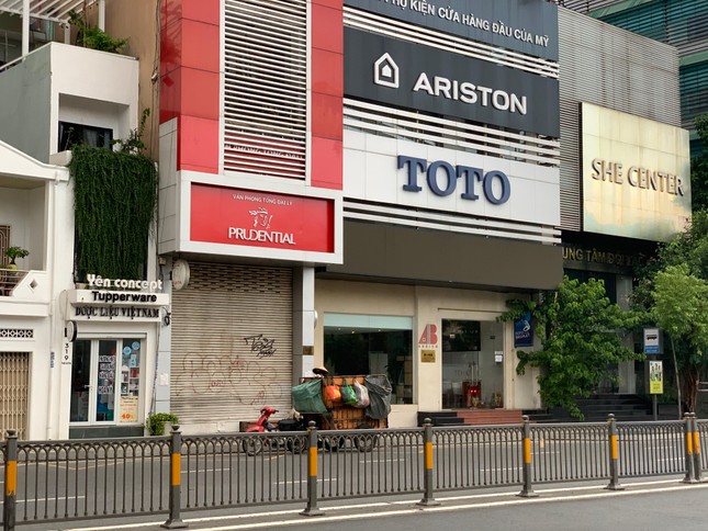 Hai người lao công già với chiếc xe gom rác thủ công gõ cửa từng nhà bên con đường đẹp từ sân bay Tân Sơn Nhất vào trung tâm thành phố