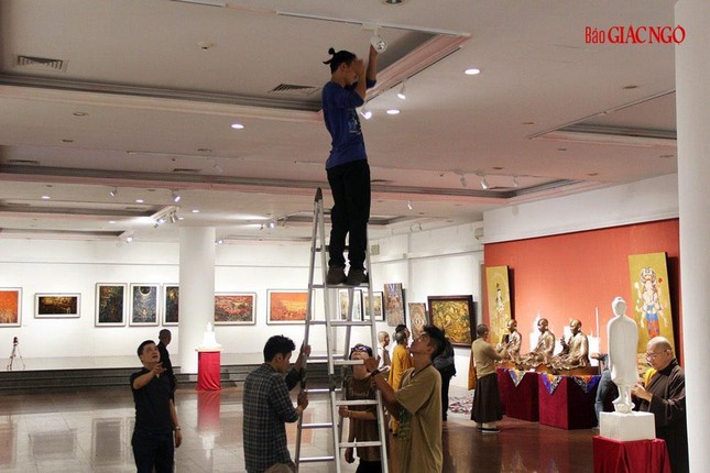 Treo tranh và cân chỉnh ánh sáng chuẩn bị cho triển lãm Sen đầu hạ chào mừng Đại hội