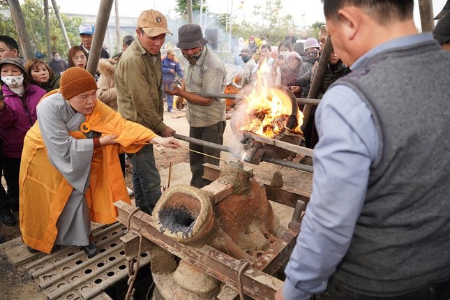 Ni sư Thích Đàm Chính và thợ đúc thực hiện nghi thức rót đồng Ni sư Thích Đàm Chính và thợ đúc thực hiện nghi thức rót đồng