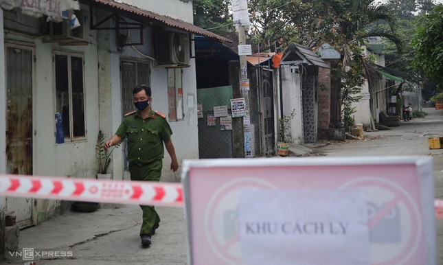 Nhân viên trung tâm y tế quận 12 đến từng hộ dân trong khu phong tỏa ở phường Thạnh Lộc, quận 12, để đưa giấy khai báo y tế, sáng 8-2 - Ảnh: Đình Văn/ VNE