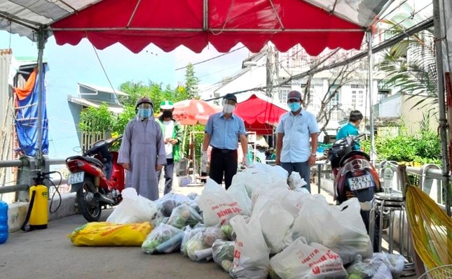 Sư cô TN Lệ Nhân, chùa Pháp Võ; ông Nguyễn Văn Hưng, Chủ tịch UBMTTQ xã Phú Xuân; Phật tử Minh Hạnh, Phó Giám đốc Trung tâm Mồ côi Pháp Võ trao quà tại khu phong tỏa - Ảnh: CTV