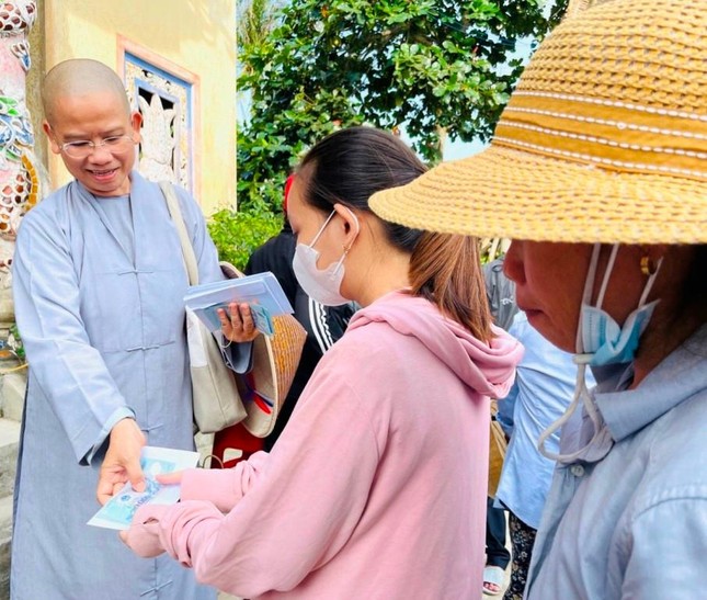 Ni sư Thích nữ Pháp Hạnh trao phong bì cho bà con vùng lũ