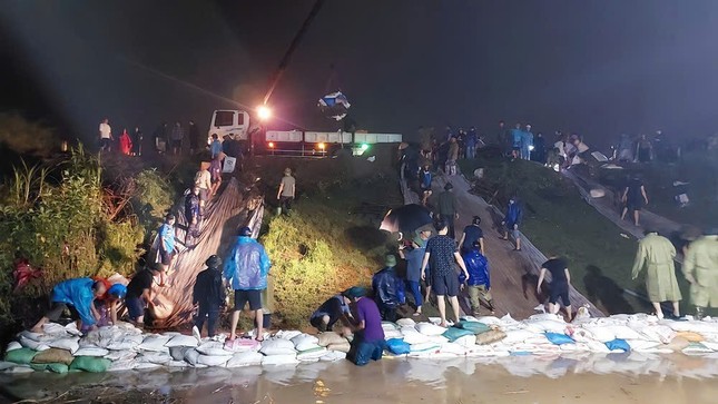 Bà con đang gia cố bờ đê - Ảnh: T.N