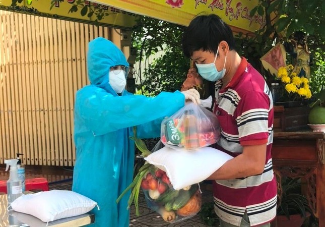 Tình nguyện viên trao quà đến người dân - Ảnh: TG