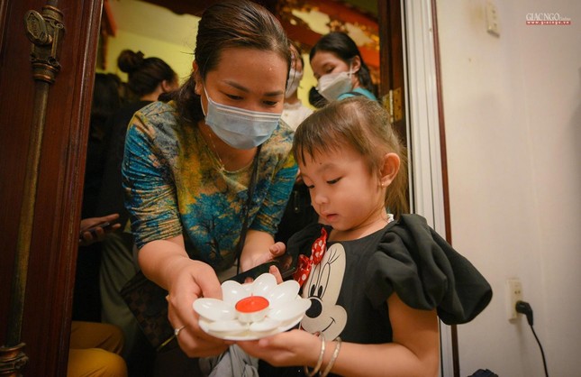 Em theo mẹ đến chùa thả hoa đăng cầu nguyện bình an