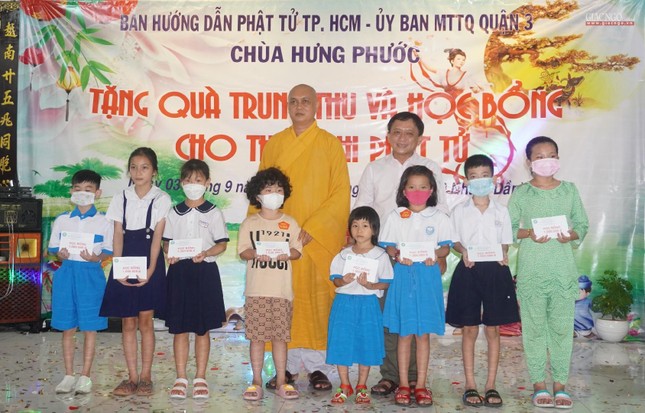 Thượng tọa Thích Thiện Chơn, Phó Trưởng Thường trực Ban Hướng dẫn Phật tử TP.HCM, cùng ông Nguyễn Ngọc Châu trao các suất học bổng đến các em