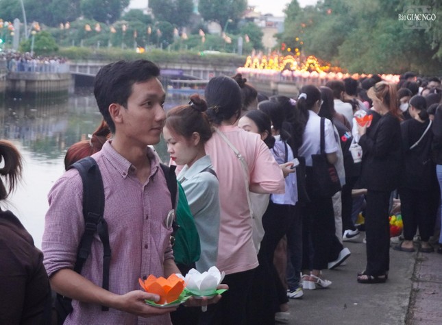 Các bạn trẻ dự lễ đứng dọc hai bên bờ kênh Nhiêu Lộc hướng về chùa Pháp Hoa