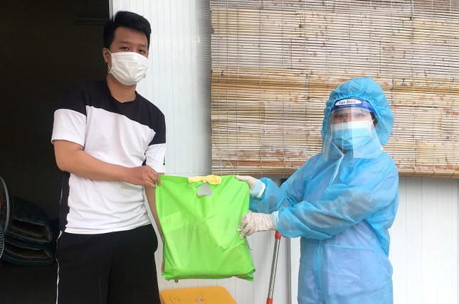 Nhân viên y tế tại khu cách ly hỗ trợ chùa Pháp Vân gửi quà đến người dân đang tham gia cách ly