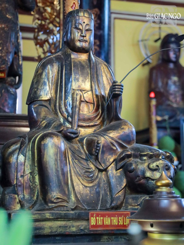 Văn Thù Bồ-tát tay cầm nhành như ý, ngồi trên lưng sư tử