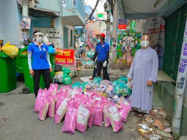 Ni sư Thích nữ Huệ Thắng, trụ trì chùa Hoa Đàm hỗ trợ quà đến người dân khu cách ly