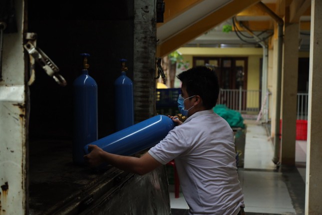 Phật tử vận chuyển bình oxy lên xe để hỗ trợ cho bà con F0 Covid-19 điều trị tại nhà tại tỉnh An Giang vào chiều 26-9 - Ảnh: Phùng Anh Quốc