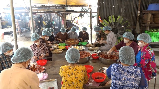 Các thành viên của bếp ăn chế biến món ăn chay để trao tặng cho người dân