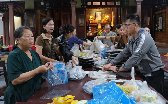 Phật tử Nguyễn Thị Huê (áo xanh) đang cùng mọi người tích cực chia các phần cơm, nước uống vào bịch Phật tử Nguyễn Thị Huê (áo xanh) đang cùng mọi người tích cực chia các phần cơm, nước uống vào bịch