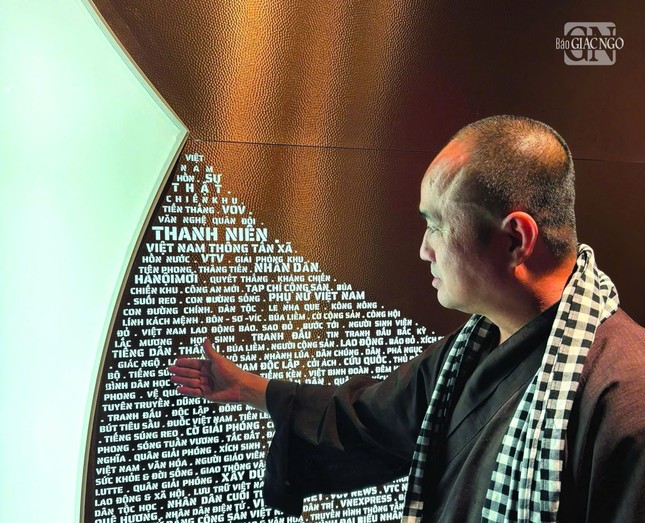 Thượng tọa Thích Tâm Hải trước biểu tượng có khắc tên Báo Giác Ngộ tại Bảo tàng Báo chí Việt Nam