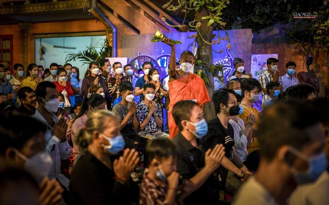 Một nhà sư trẻ đang thực hiện nghi lễ ban phước lành đến các Phật tử đang lắng nghe thuyết pháp