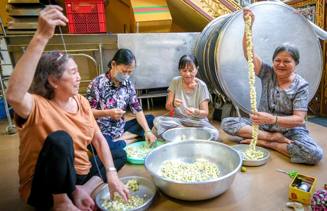 Cụ bà Ngọc Yến (góc phải), pháp danh Đồng Thủy, 66 tuổi cảm thấy rất vui khi ngồi kết những vòng hoa lài như thế này. Bà cho biết việc làm này thể hiện tấm lòng thành của mình đối với Đức Thế Tôn cũng như hy vọng bản thân sẽ có thêm nhiều phước báu hơn để tiếp tục công quả