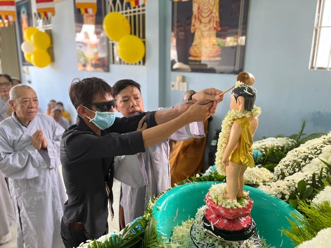 Một Phật tử đạo tràng Phước huệ song tu (huyện Nhà Bè) đang giúp một người khiếm thị thực hiện nghi thức Tắm Phật