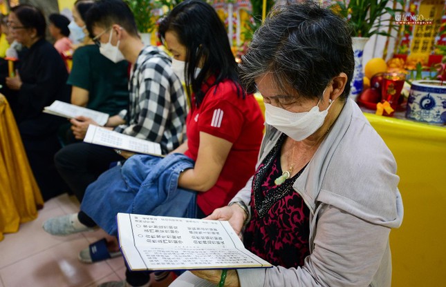 Một Phật tử người Hoa đang chăm chú tụng kinh Phật bằng tiếng Hán