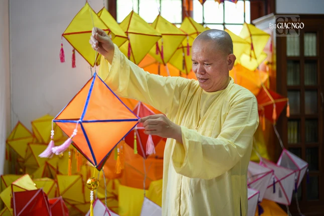 Thượng tọa Thích Tâm Chơn đang giới thiệu công năng và các công đoạn để làm chiếc lồng đèn đậm chất xứ Huế này