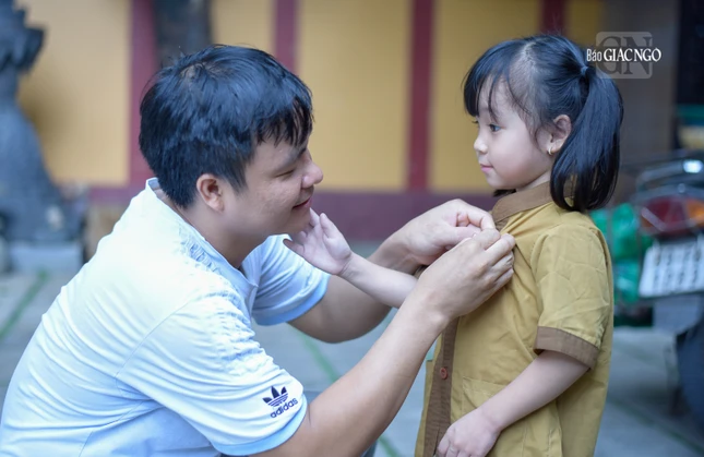 Anh Phạm Đăng Hùng (32 tuổi), ba bé Bông đang chỉnh sửa lại hoa hồng trên ngực của con gái