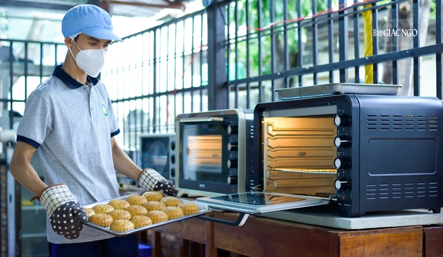 Bạn trẻ Phạm Quốc Bảo (1997), pháp danh Chánh Báu đang lấy mẻ bánh vừa nướng xong ra khỏi lò nướng