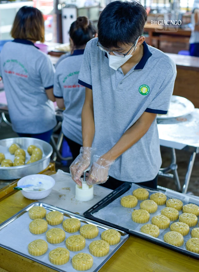 Mọi người đều đeo khẩu trang, găng tay để tránh tiếp xúc trực tiếp khi làm bánh