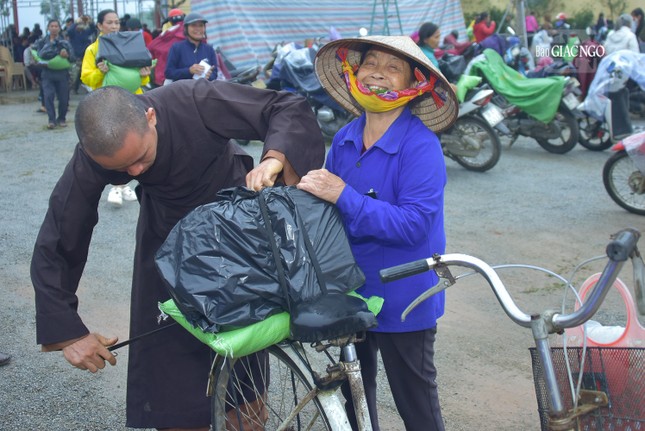 Một thành viên trong đoàn hỗ trợ người dân nhận quà