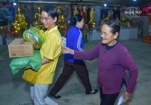 Các tình nguyện viên hỗ trợ người dân nhận quà