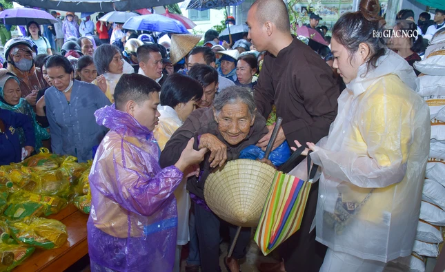 Hình ảnh một cụ già lớn tuổi được các tình nguyện viên chùa Long Hương hỗ trợ nhận quà