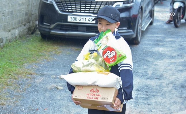 Một em học sinh vui vẻ nhận món quà của mình