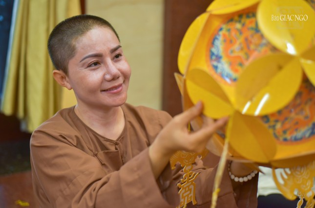 Nụ cười của một nữ Phật tử đang làm lồng đèn tại Việt Nam Quốc Tự