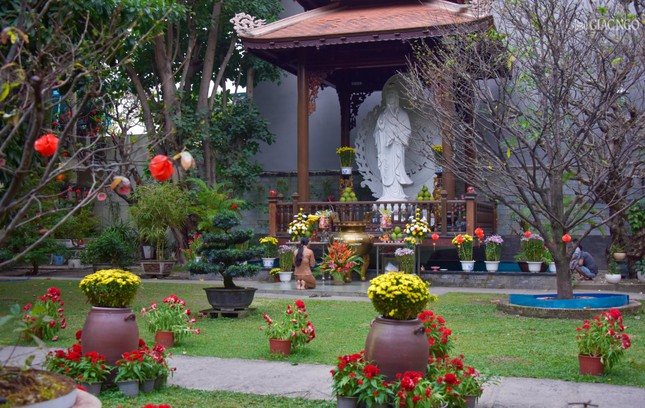 Một Phật tử cầu nguyện dưới chân Bồ-tát Quán Thế Âm trong khuôn viên chùa