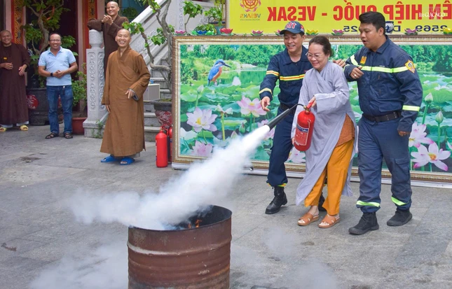 Cán bộ phòng cháy chữa cháy hướng dẫn Phật tử thực hiện kỹ năng xử lý đám cháy