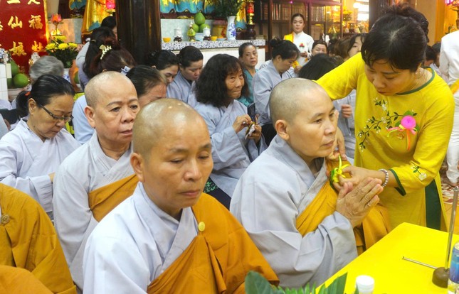 Phật tử cài hoa hồng cho chư Ni - Ảnh: Hoàng Phương