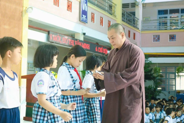 Đại đức Thích Lệ Lạc trao quà đến các em học sinh